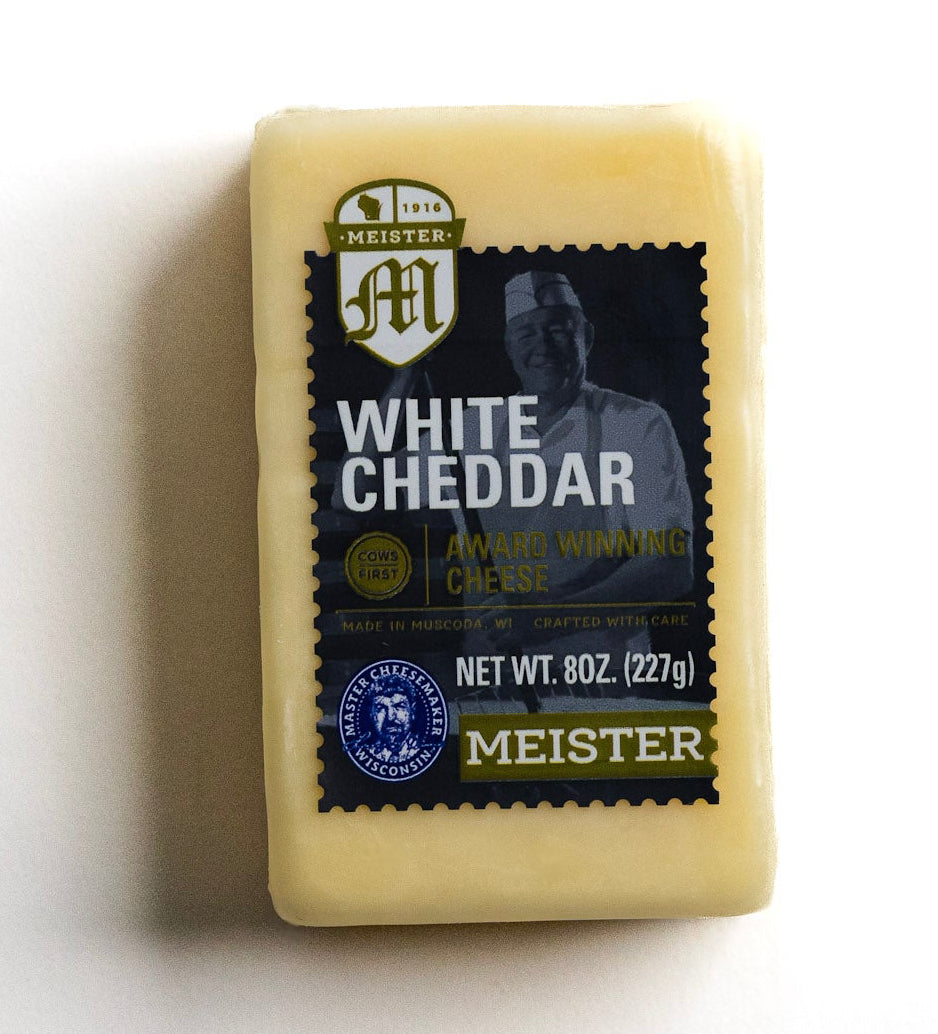 Block of Meister White Cheddar cheese on a white background