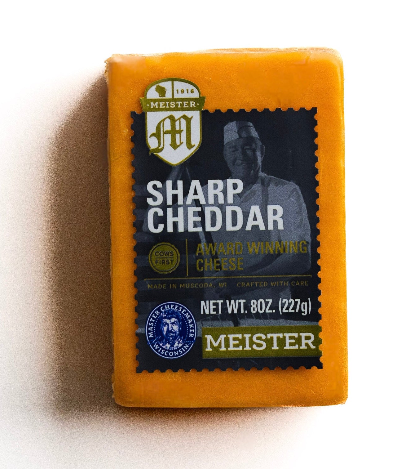 Block of Meister Sharp Cheddar cheese on a white background